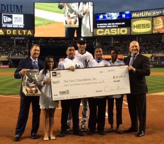 NY Yankee SS Derek Jeter (center) receives a union-made bronzed baseball cap (far left) during a retirement ceremony recognizing his charitable foundation.