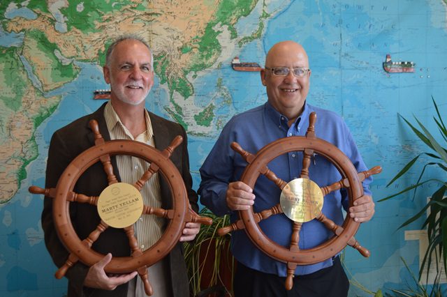 Displaying their ship’s wheels from the Puget Sound Ports Council are Marty Yellam (left) and Larry Brown.