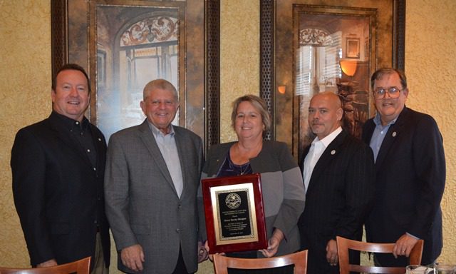 Outgoing PMC Sec-Treas Becky Sleeper shows her plaque of appreciation from the MTD and the Greater St. Louis Area and Vicinity Port Council. Surrounding her are (from left) PMC VP John Stiffler, PMC Pres Jack Martorelli, incoming PMC Sec-Treas Chad Partridge and MTD Exec Sec-Treas Daniel Duncan. 